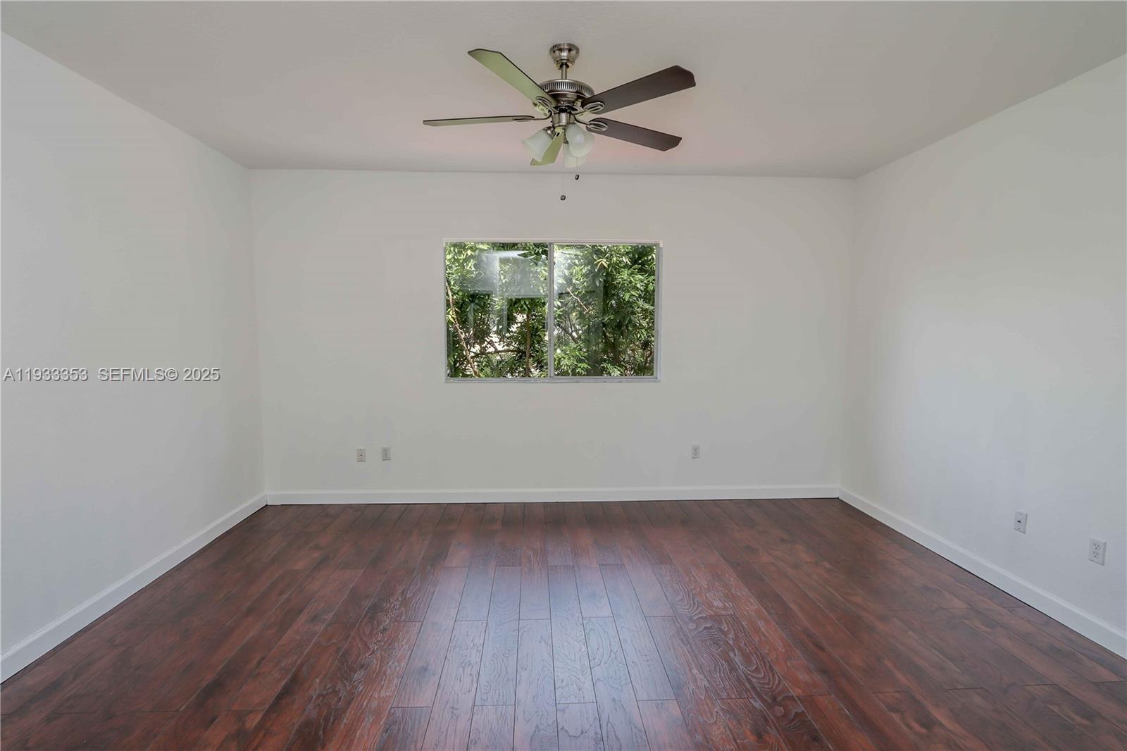 846 Southwest 148th Place Miami, FL 33194 - Photo 25 of 32 an empty room with wooden floor chandelier fan and windows