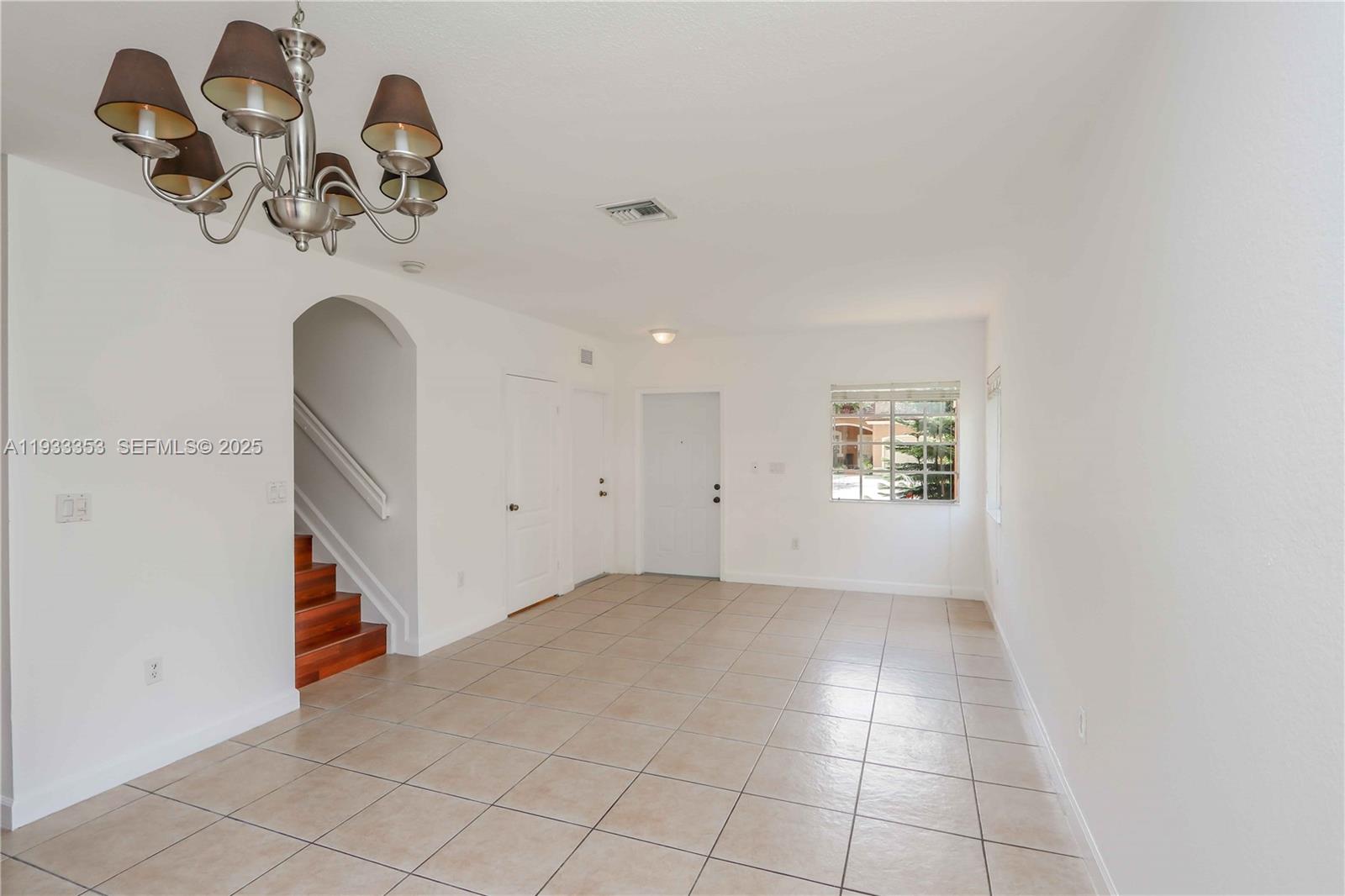 846 Southwest 148th Place Miami, FL 33194 - Photo 9 of 32 an empty room with a chandelier fan and wooden floor