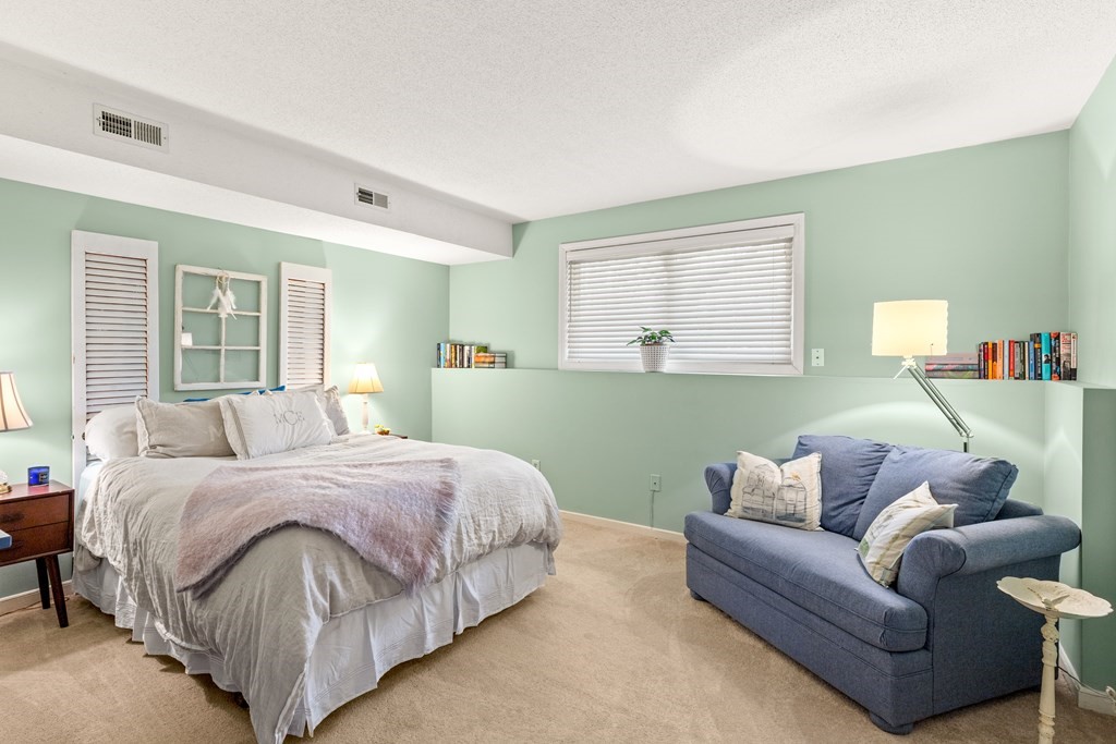 4873 Washington Street, Unit 1 Boston, MA 02132 - Photo 14 of 25 a spacious bedroom with a bed couch and windows