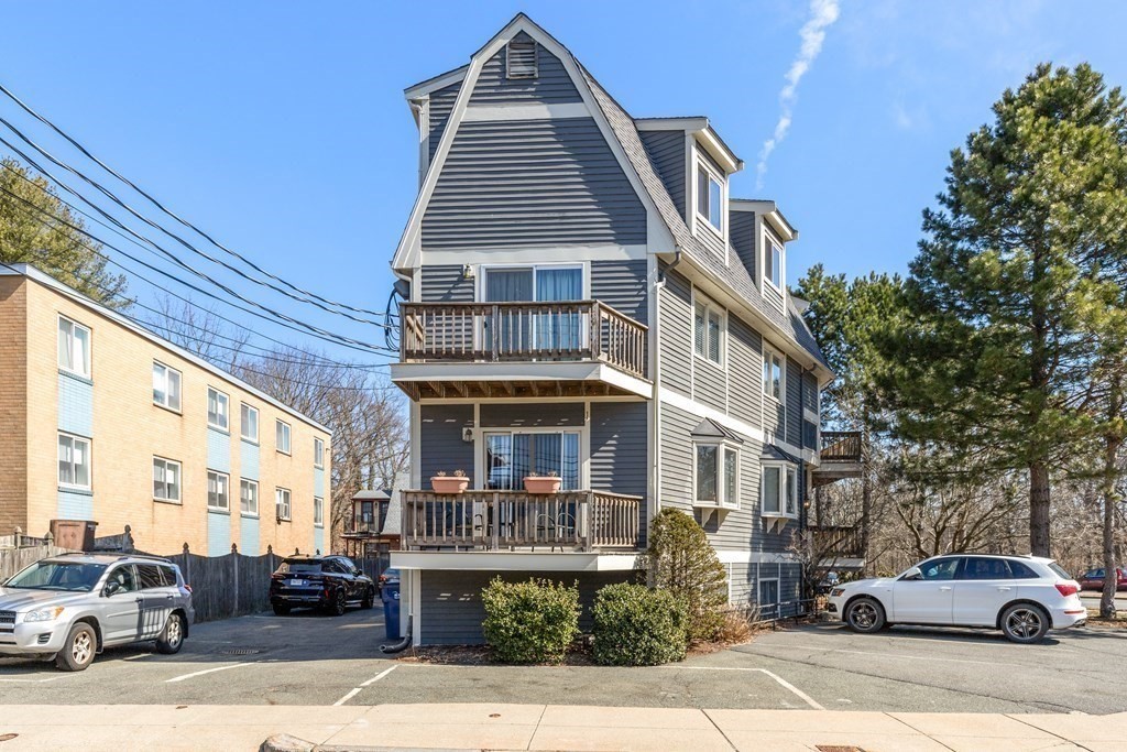 4873 Washington Street, Unit 1 Boston, MA 02132 - Photo 23 of 25 a front view of a residential apartment building with a yard