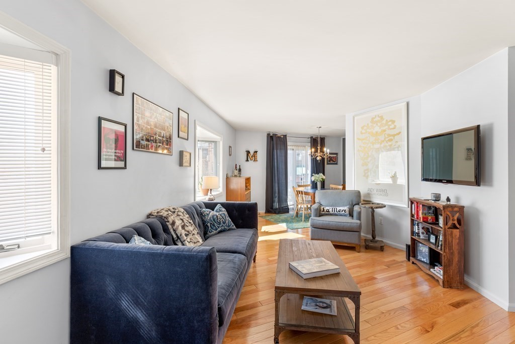 4873 Washington Street, Unit 1 Boston, MA 02132 - Photo 4 of 25 a living room with furniture and a flat screen tv
