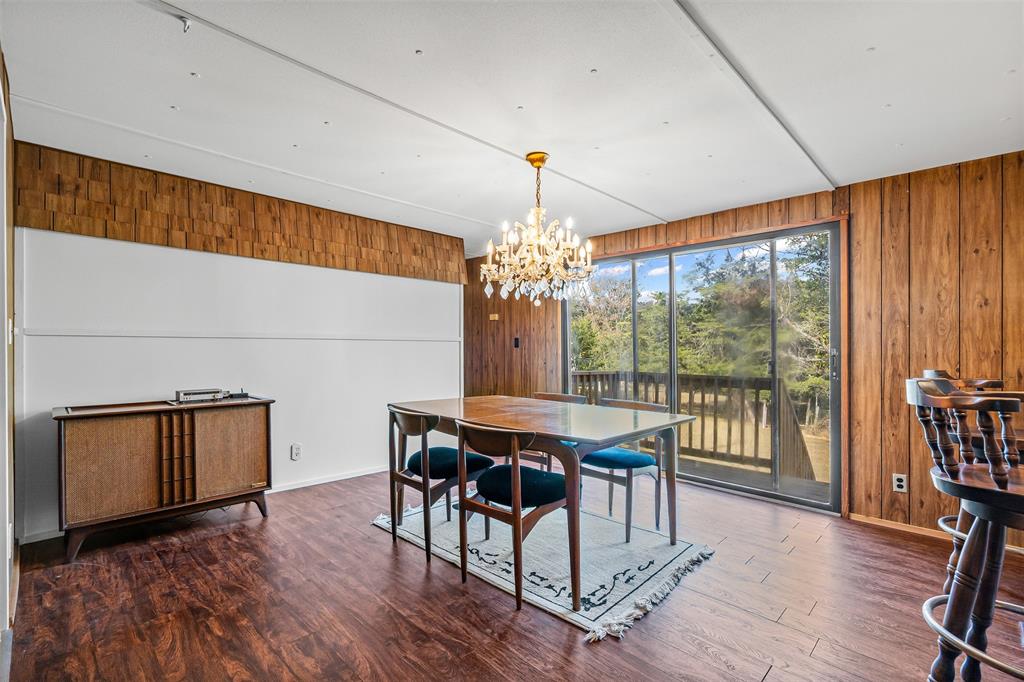 3667 Oak Circle Weatherford, TX 76088 - Photo 18 of 35 Dining space with wood walls, a chandelier, and wood finished floors