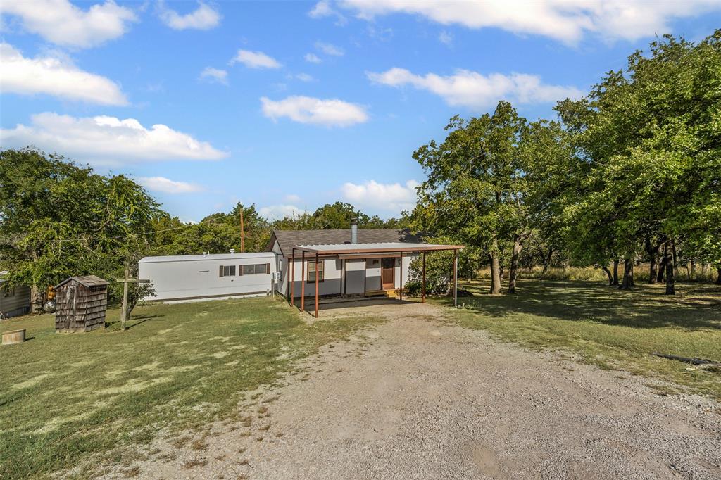 3667 Oak Circle Weatherford, TX 76088 - Photo 4 of 35 View of front facade featuring a front lawn, driveway, a carport, and an outdoor structure