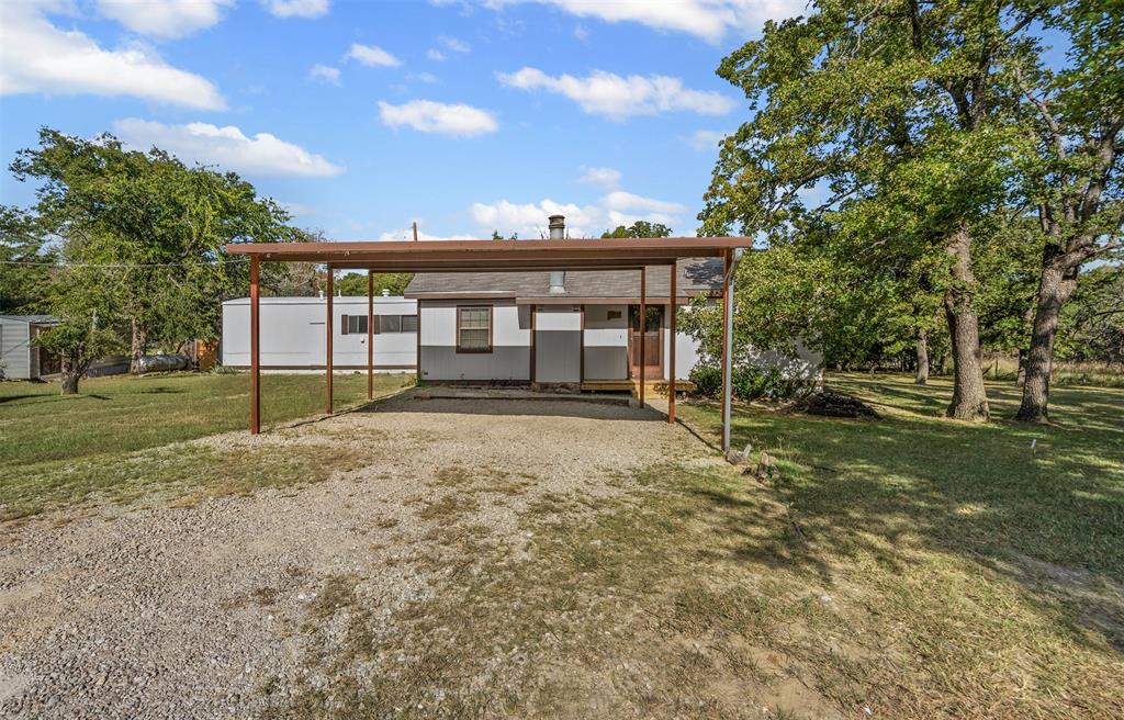 3667 Oak Circle Weatherford, TX 76088 - Photo 6 of 35 Rear view of property featuring a lawn, gravel driveway, and a carport
