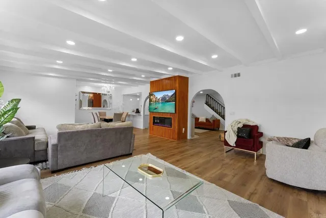 a living room with furniture and a wooden floor