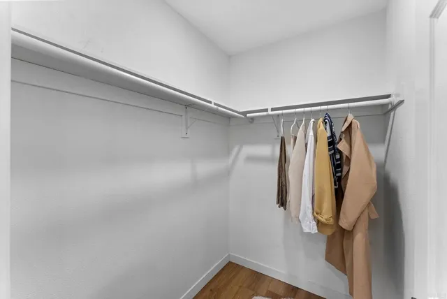 a view of walk in closet with clothes and shoes