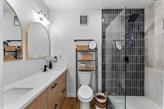 a bathroom with a toilet sink vanity and mirror