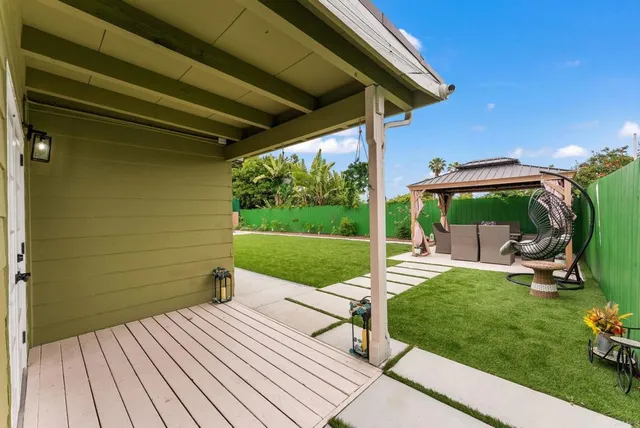 a view of a patio with table and chairs potted plants with wooden floor and fence