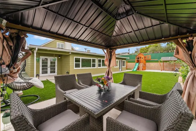 a view of a patio with a table chairs and a backyard