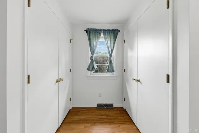 a view of a hallway with wooden door and entryway