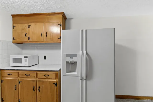 a kitchen with stainless steel appliances granite countertop a refrigerator and a stove