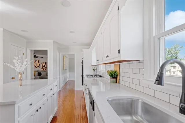 a kitchen with white cabinets and sink
