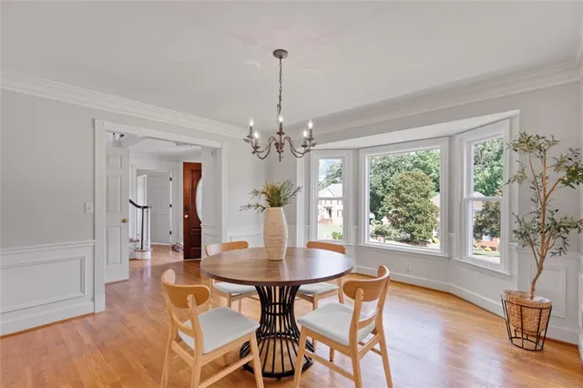 a dining room with furniture a chandelier and wooden floor