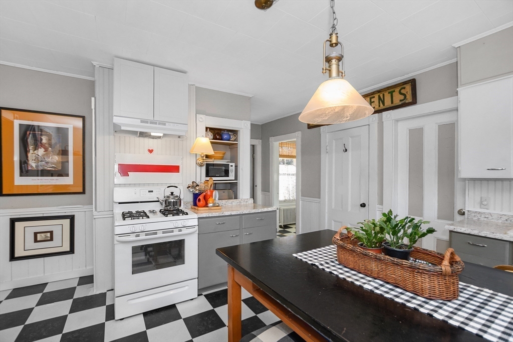 41 Walnut Street Hudson, MA 01749 - Photo 12 of 15 a living room with kitchen island a stove a sink and a potted plant