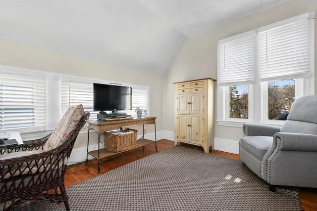 a living room with furniture a flat screen tv and a window