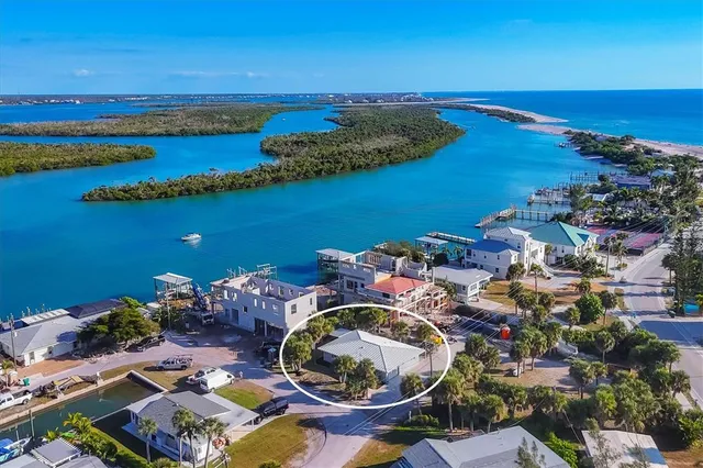 an aerial view of a city with lots of residential buildings and ocean view in back