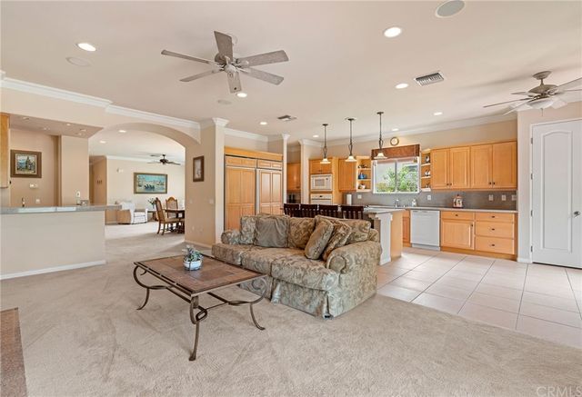a large white kitchen with kitchen island granite countertop lots of white cabinets a sink and dishwasher