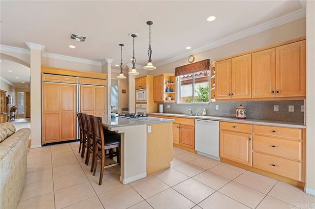 a living room with furniture kitchen view and a chandelier