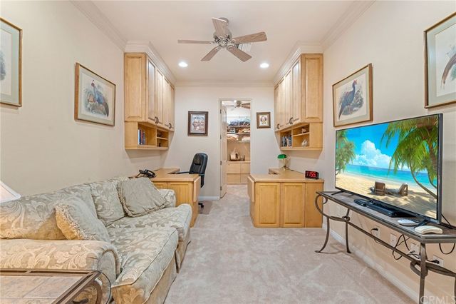 a bedroom with a bed ceiling fan and a wooden floor