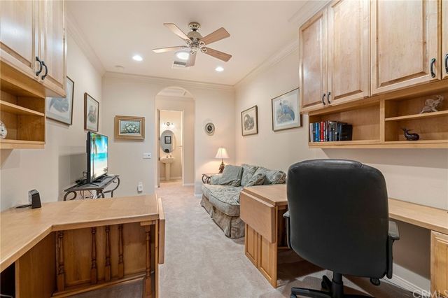 a spacious bedroom with a bed a chandelier and a large window