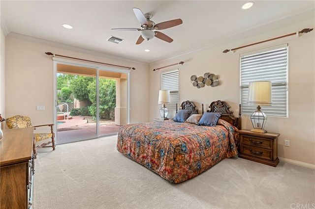 a spacious bedroom with a large bed and a chandelier