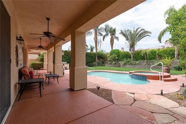 a view of a swimming pool with a bench and trees around
