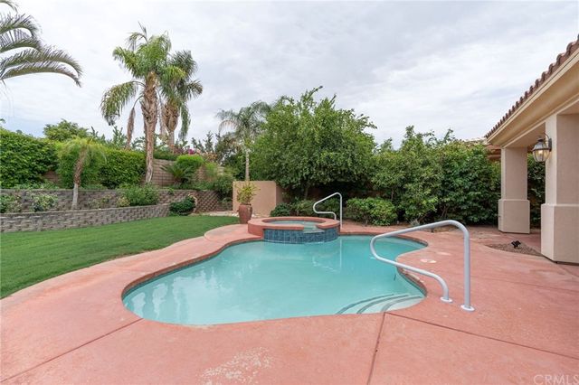 a view of a house with swimming pool and a yard