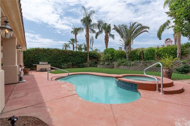a view of a house with a yard patio and swimming pool