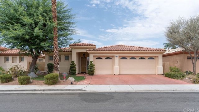 a front view of a house with a garden and plants