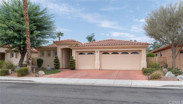 a vase with flowers sitting on a table in front of gate