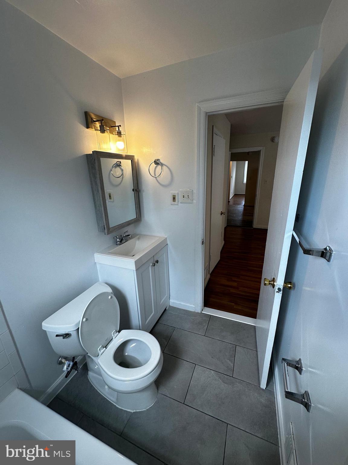 214 10th Street Laurel, MD 20707 - Photo 101 of 118 a bathroom with a toilet a sink and mirror