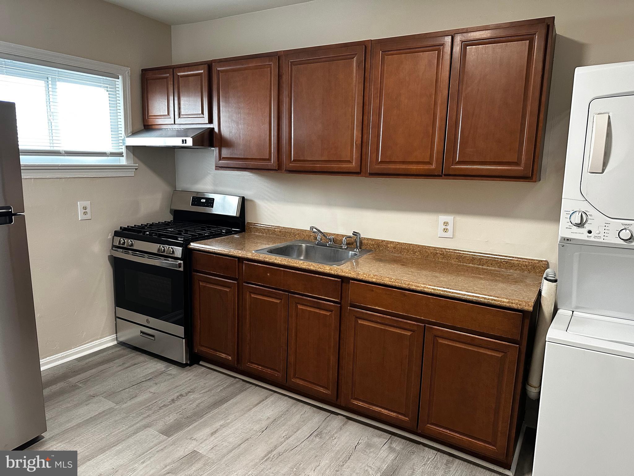 214 10th Street Laurel, MD 20707 - Photo 34 of 118 a kitchen with granite countertop wooden cabinets and a stove top oven