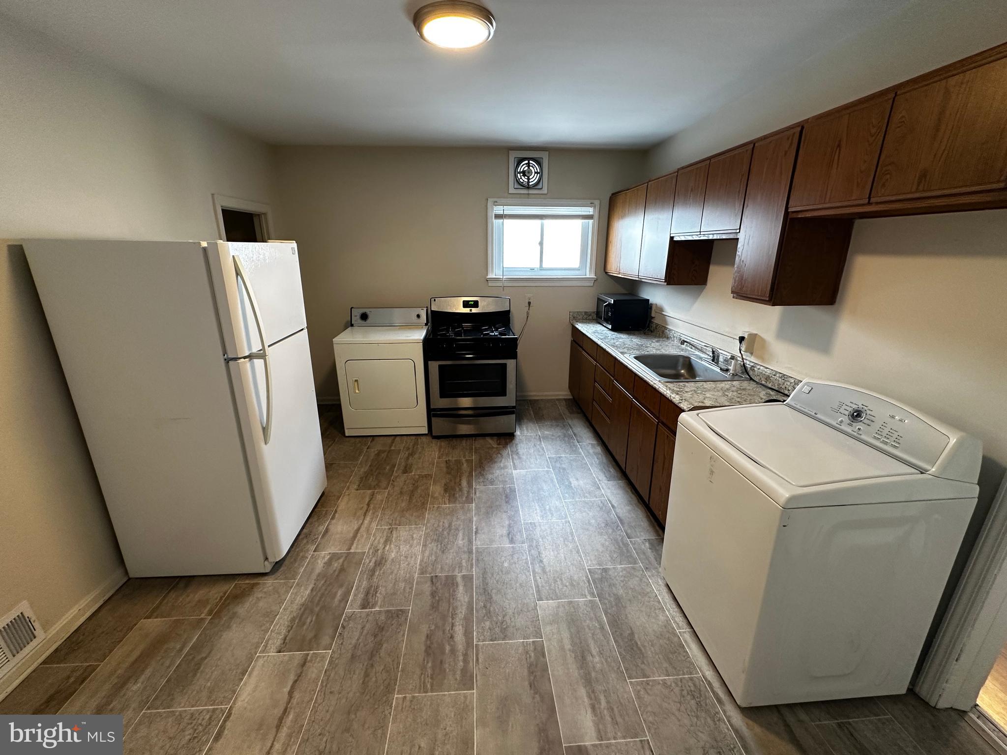 214 10th Street Laurel, MD 20707 - Photo 86 of 118 a kitchen with sink a refrigerator and a stove top oven