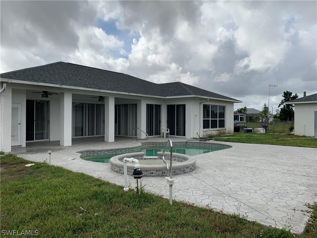 212 Danby Road Lehigh Acres, FL 33936 - Photo 17 of 21 a view of a house with backyard sitting area and garden