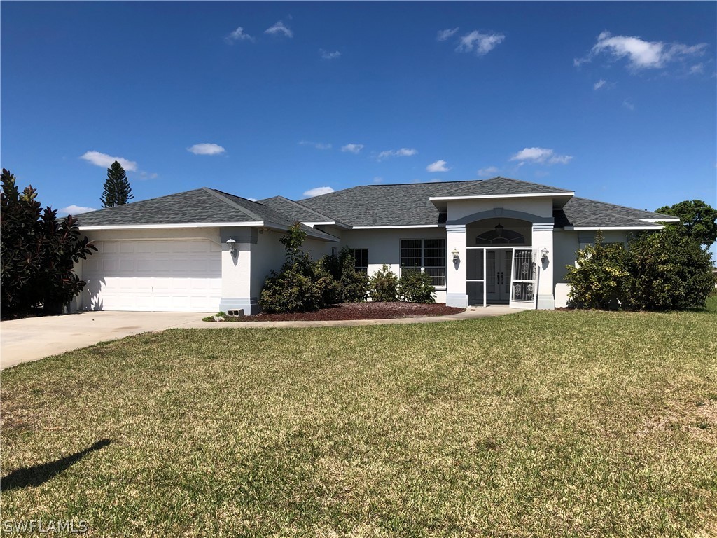 212 Danby Road Lehigh Acres, FL 33936 - Photo 2 of 21 a front view of a house with a yard