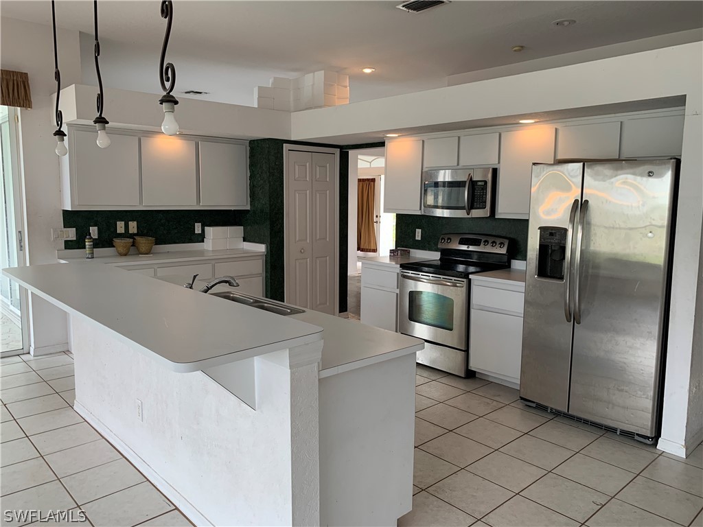 212 Danby Road Lehigh Acres, FL 33936 - Photo 7 of 21 a kitchen with granite countertop a refrigerator and a sink