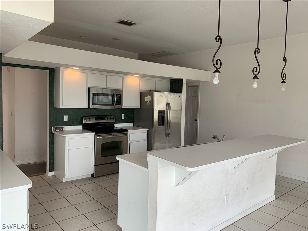 212 Danby Road Lehigh Acres, FL 33936 - Photo 8 of 21 a kitchen with a refrigerator a stove top oven a sink and dishwasher