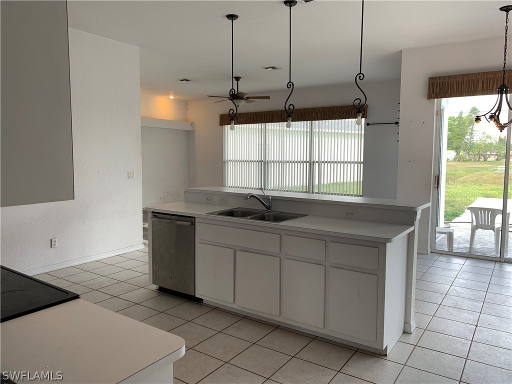212 Danby Road Lehigh Acres, FL 33936 - Photo 10 of 21 a kitchen with kitchen island a sink a counter top space and cabinets