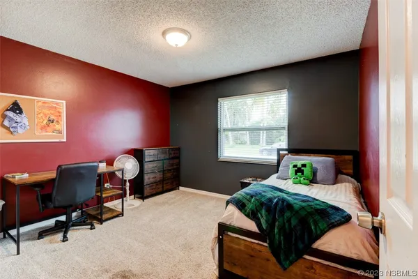 a bedroom with a bed and a desk