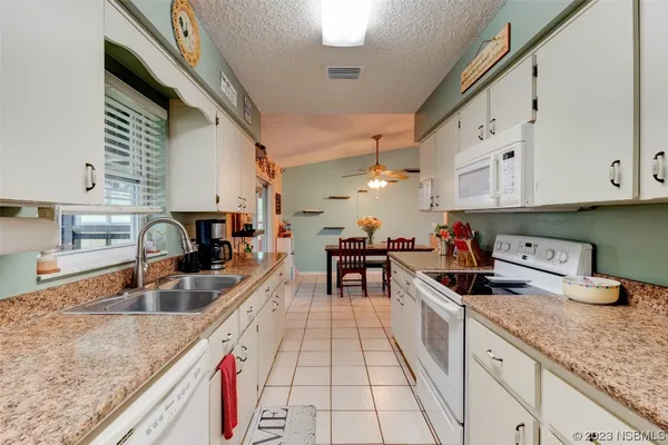 a kitchen with granite countertop a sink a stove and cabinets