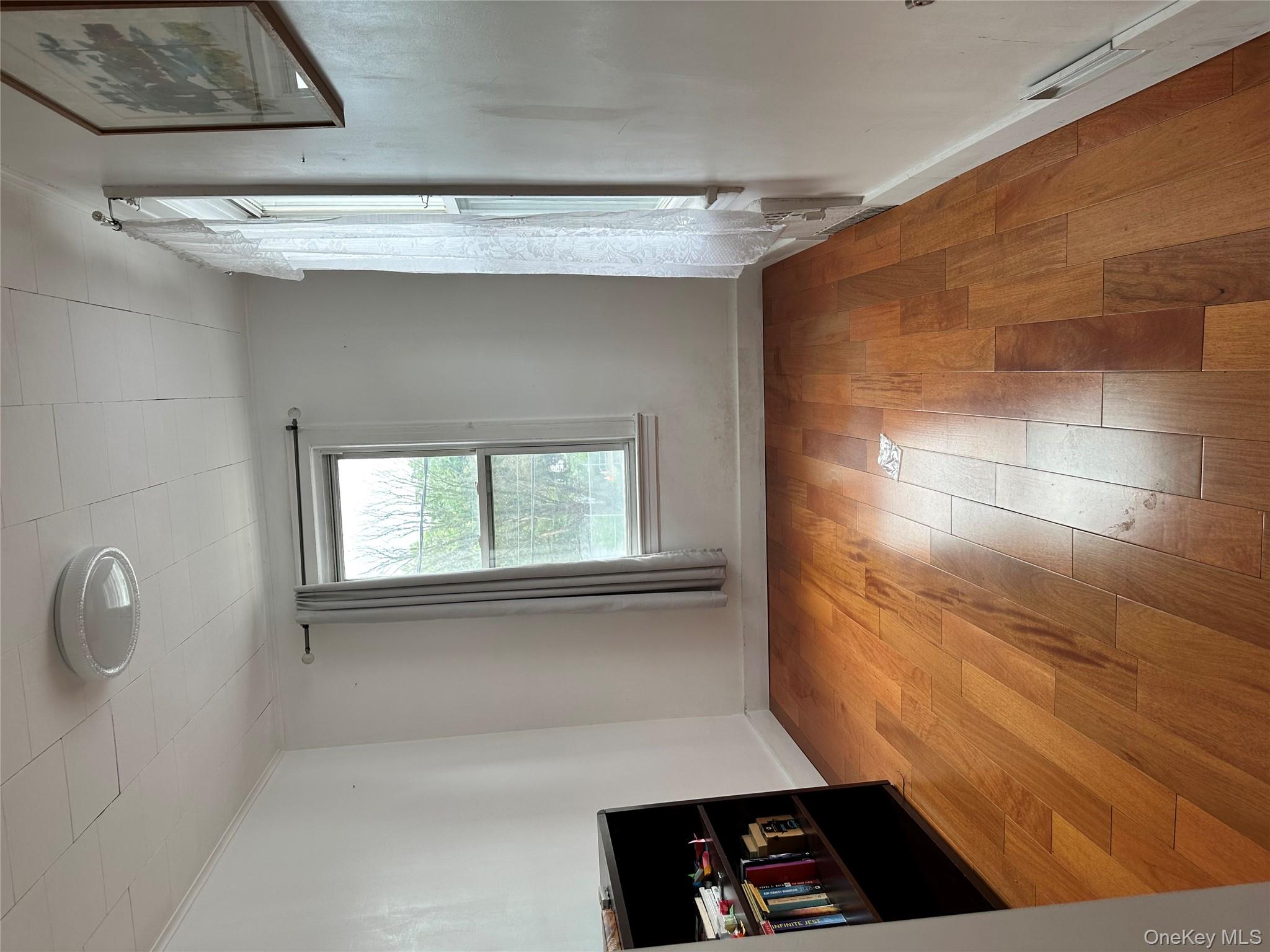 77-02 164th Street, Unit 2 Queens, NY 11366 - Photo 11 of 17 an empty room with wooden floor and windows