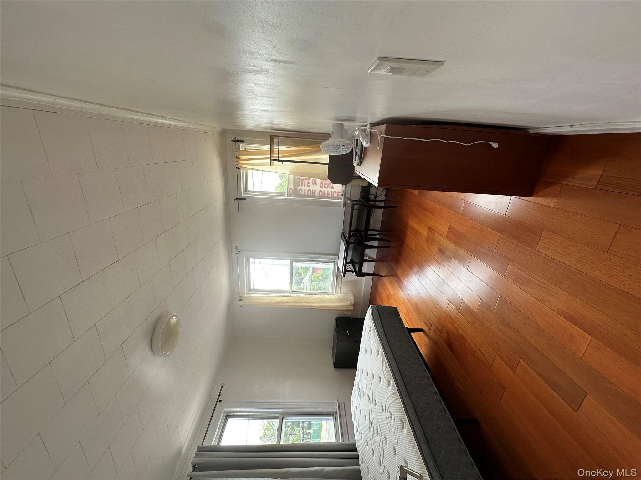 77-02 164th Street, Unit 2 Queens, NY 11366 - Photo 14 of 17 a bedroom with furniture and a wooden floor