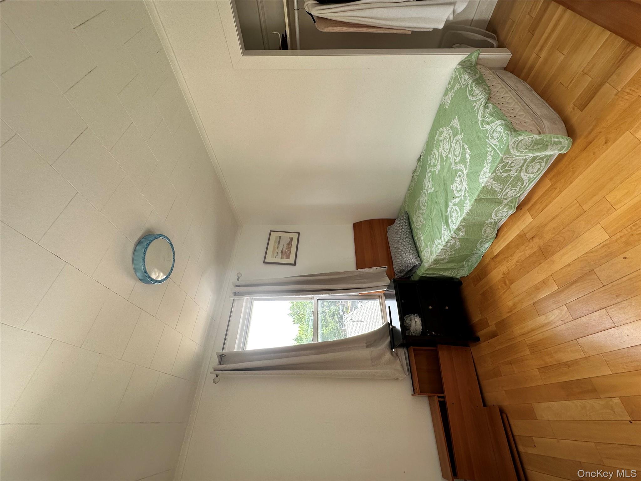 77-02 164th Street, Unit 2 Queens, NY 11366 - Photo 15 of 17 a bedroom with a bed and a window