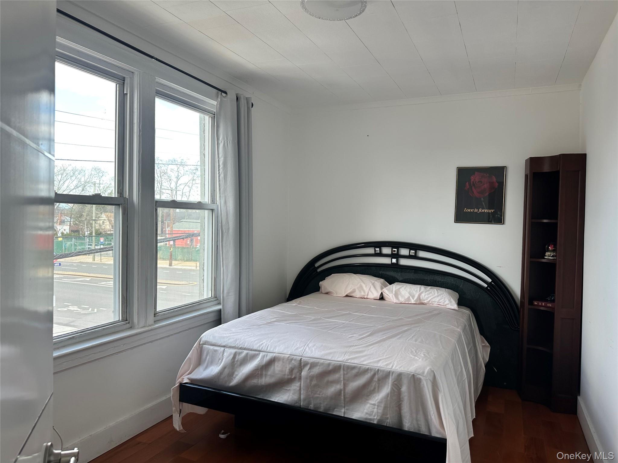 77-02 164th Street, Unit 2 Queens, NY 11366 - Photo 6 of 17 a bedroom with a bed and a window
