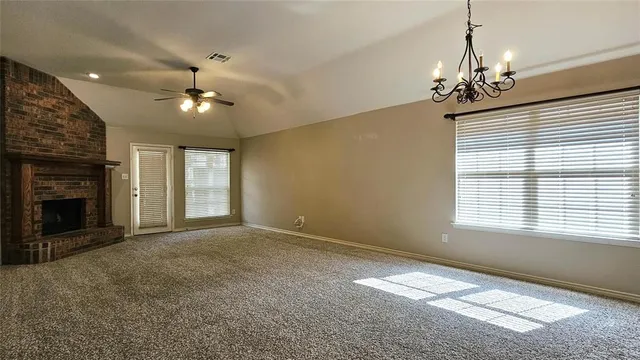 a view of an empty room with a fireplace and a window