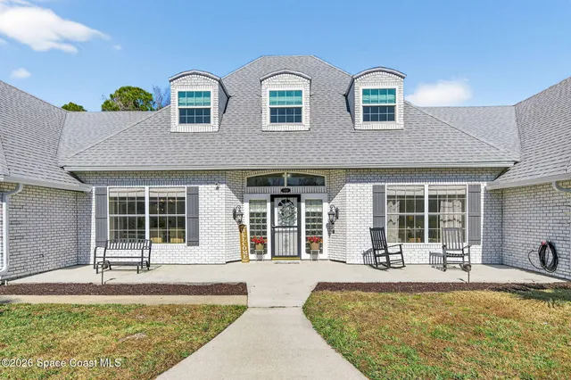 a dining room with furniture a rug and a floor to ceiling window