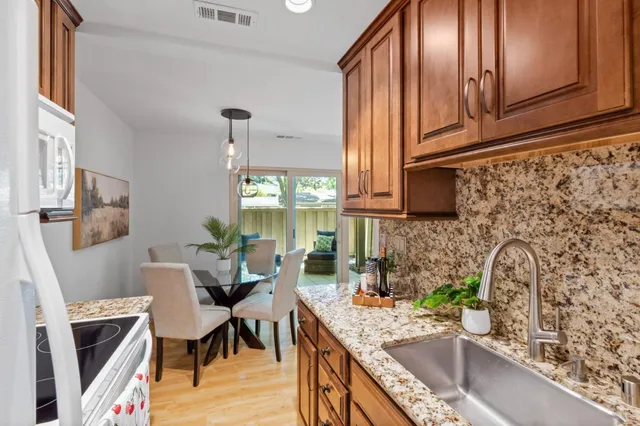 a kitchen with stainless steel appliances granite countertop a sink stove and cabinets