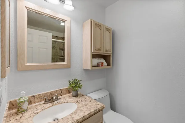 a bathroom with a granite countertop sink and a mirror