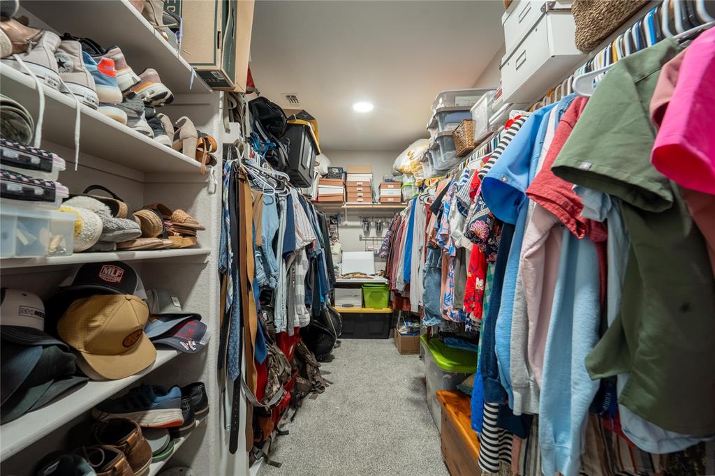 5521 Wisdom Court Waco, TX 76708 - Photo 22 of 28 Walk-in closet with carpet flooring, recessed lighting, white built-in shelving, and multiple clothing rods