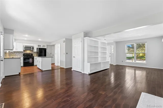 an empty room with wooden floor and fireplace